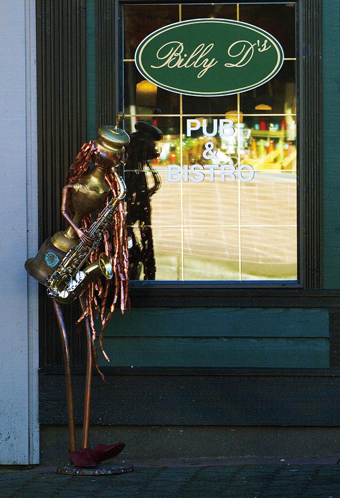 A human form sculpture playing a saxophone. Made from copper and brass upcycled pieces.