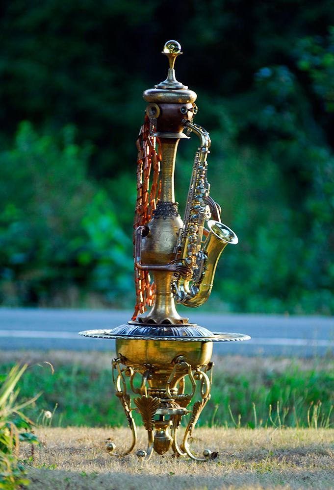 A human form sculpture playing a saxophone. Made from copper and brass upcycled pieces. 